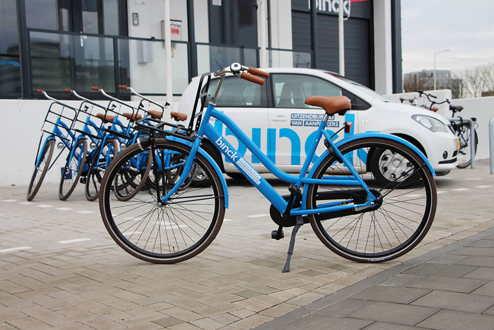 binck fiets met binck auto op de achtergrond