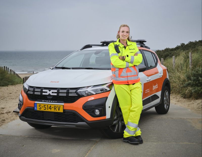 gecertificeerde verkeersregelaar poseert bij auto