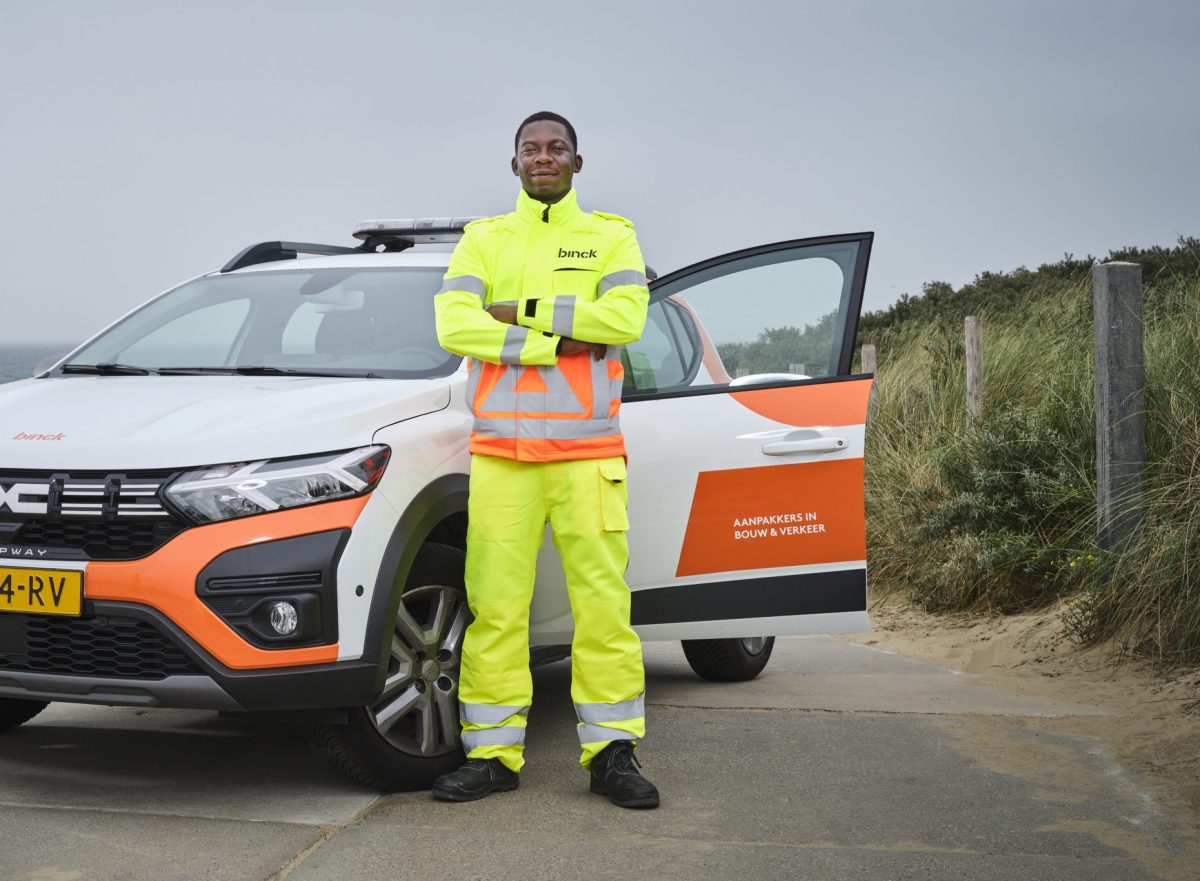 verkeersregelaar poseert naast auto